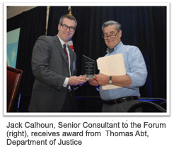 Jack Calhoun, Senior Consultant to the Forum (right), receives award from  Thomas Abt, Department of Justice